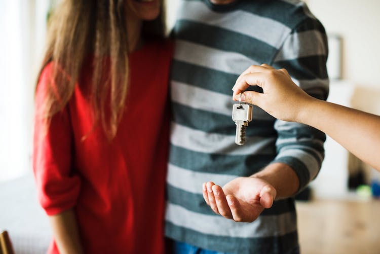 First-time home buyers being handed the keys to their new home. 