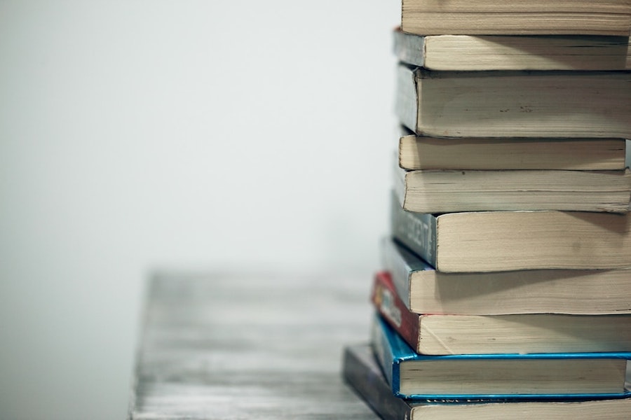 A stack of books for a home buyers course on a table. 